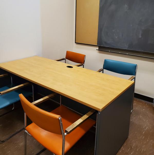 Room with 4 person table and blackboard