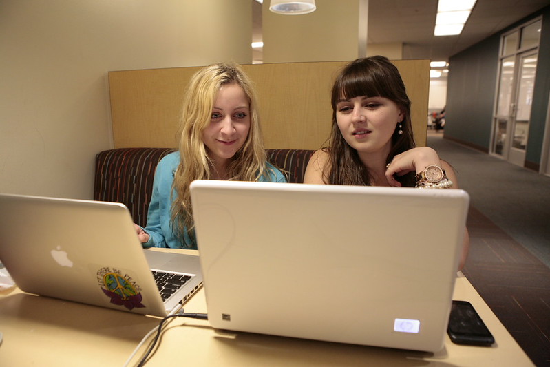 Photo of two students looking at laptops. Credit: https://www.flickr.com/photos/vculibraries/8682767785