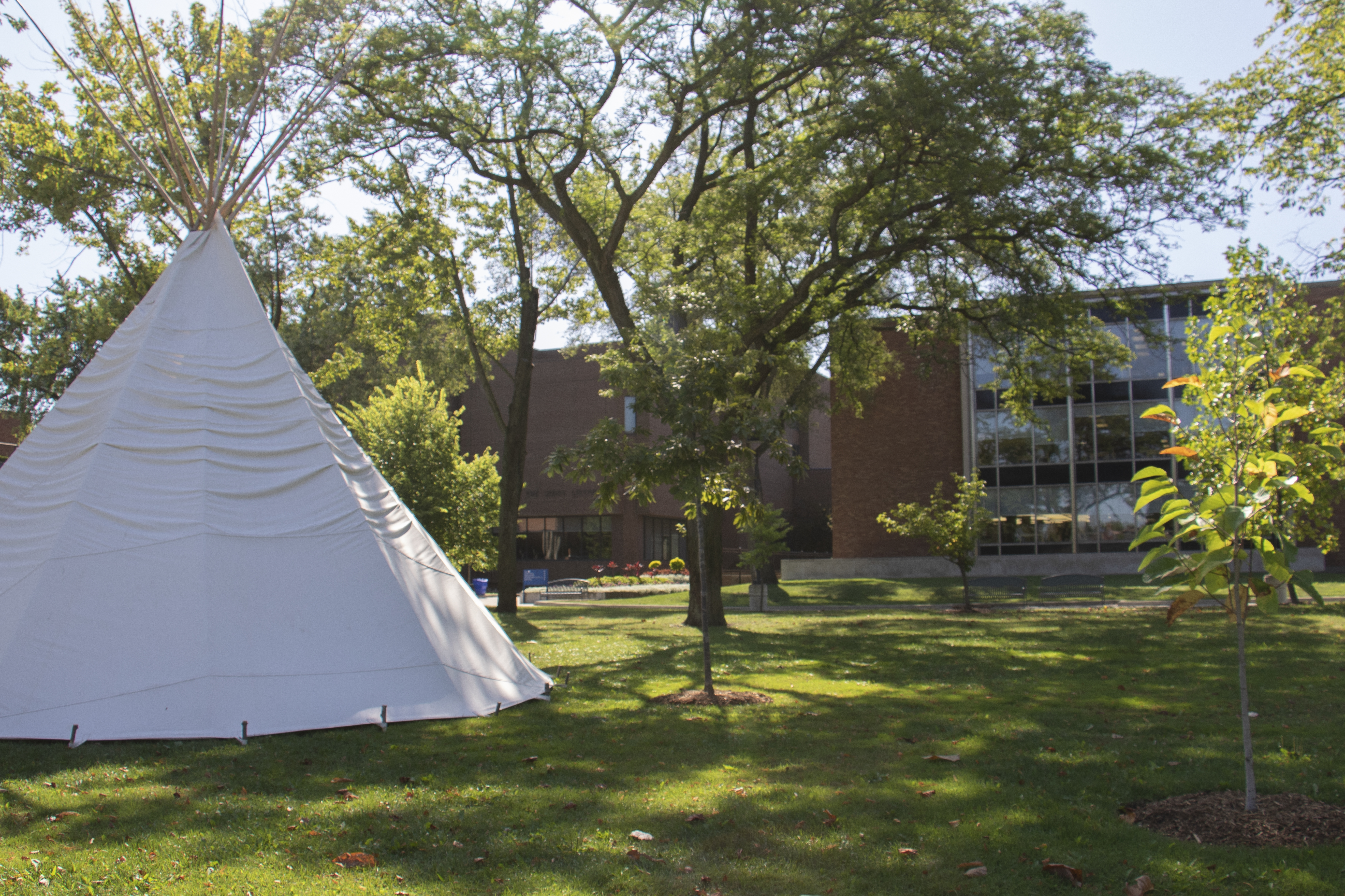Leddy Library building with tipi set up outside.