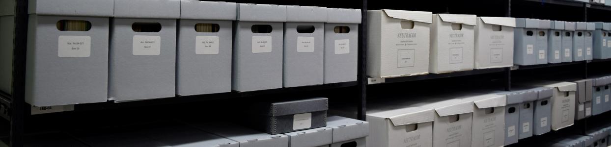 Long shelves of grey, white, and blue archival storage boxes