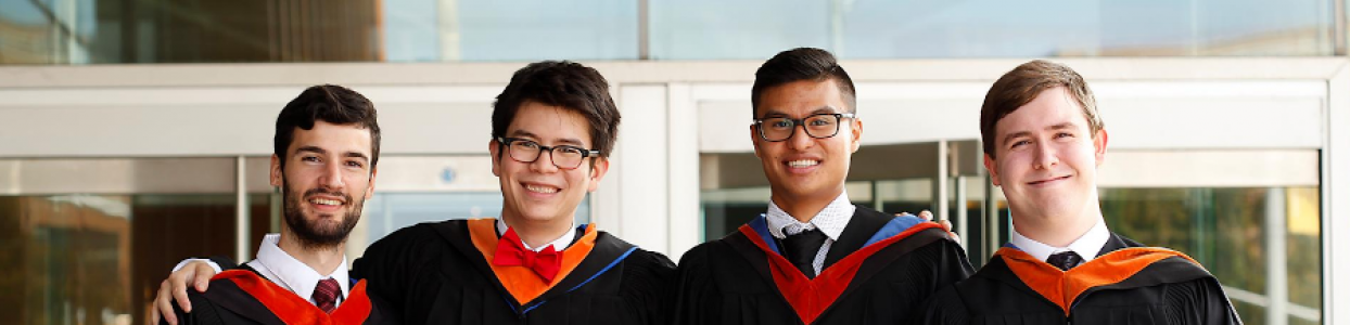 4 recent graduate students in gowns