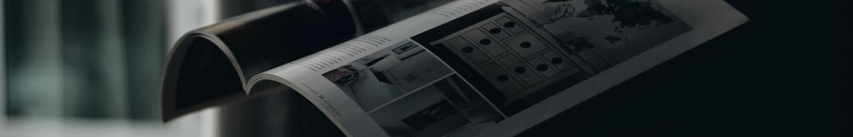 Photo of an open magazine in the air. None of the text is legible. 