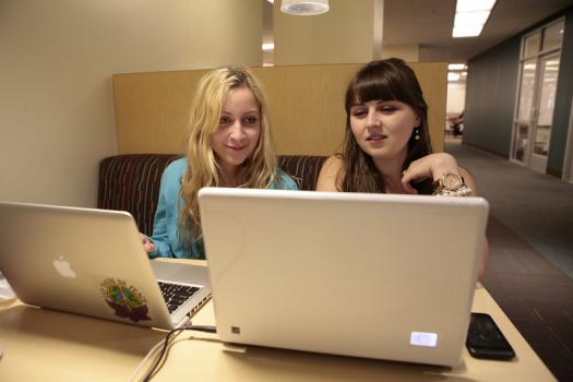 Photo of two students looking at laptops. Credit: https://www.flickr.com/photos/vculibraries/8682767785