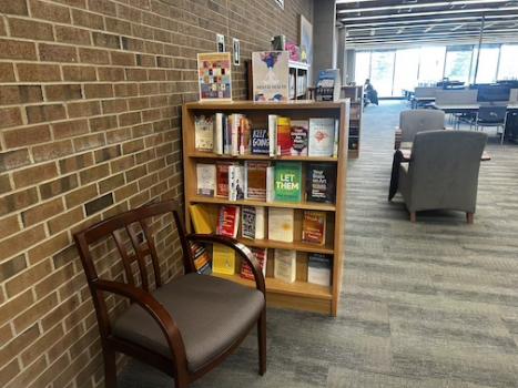 A book shelf with Mental Health Books and a chair