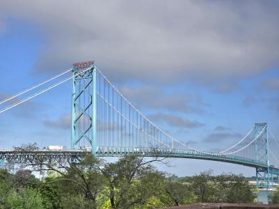 Picture of the ambassador bridge in the morning above the treeline.