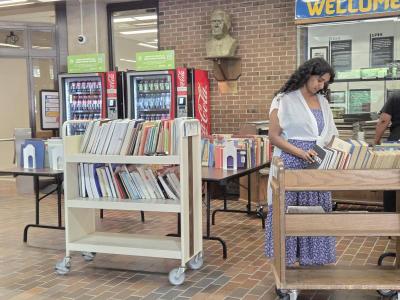 Library patron reviewing books in the giveaway carts