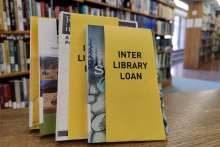 Photo of books with a yellow tag that reads "interlibrary loan"