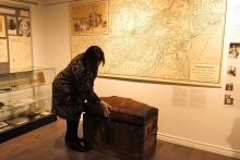 Irene Moore Davis displays an artifact at the Amherstburg Freedom Museum. Allen Watkins used this trunk to transport his children to freedom.
