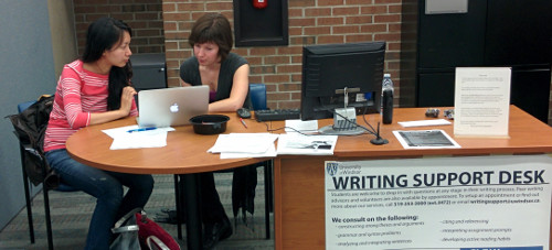 Writing help desk picture with two people working together